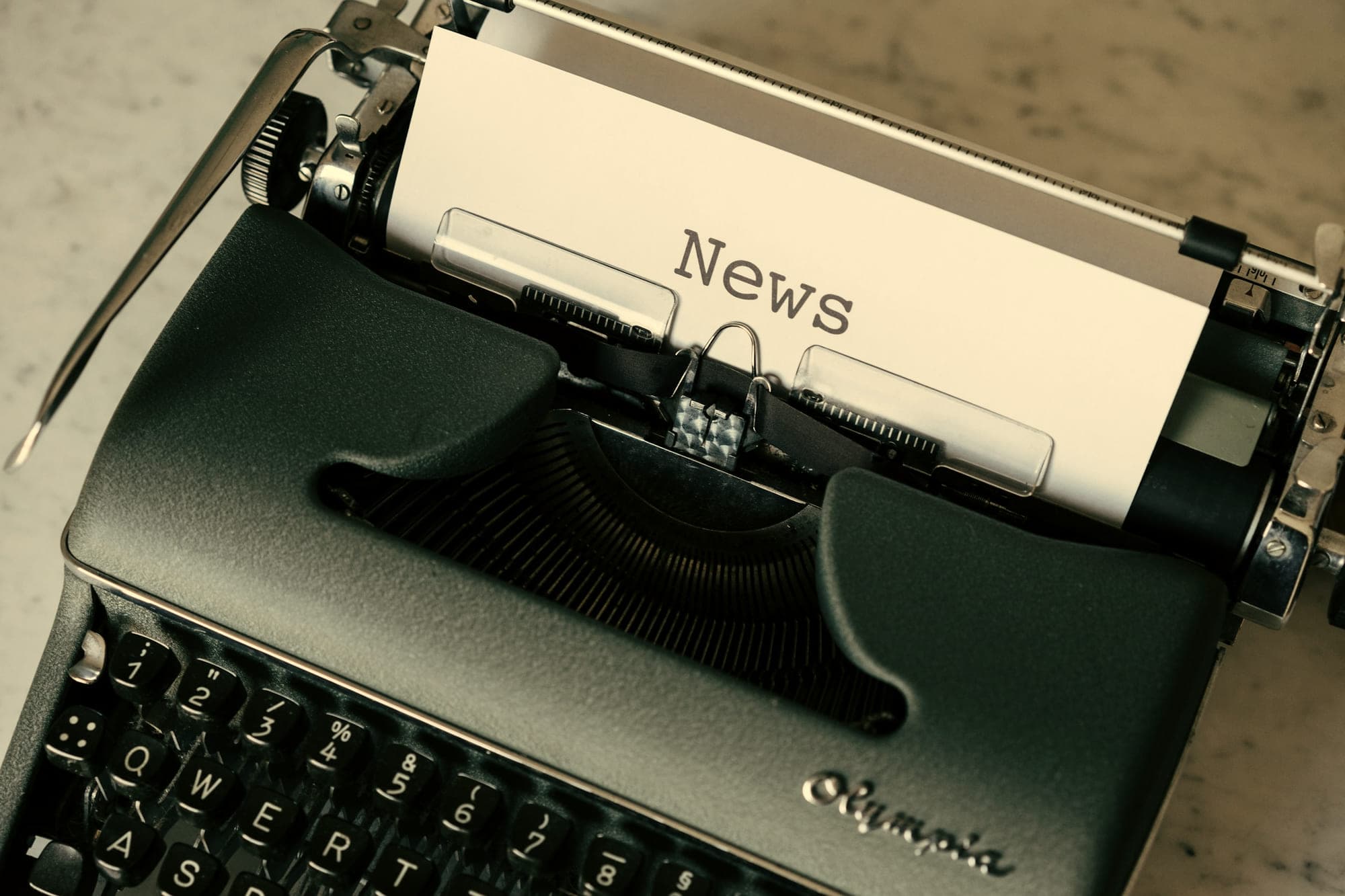 A manual typewriter with a sheet of paper headed News